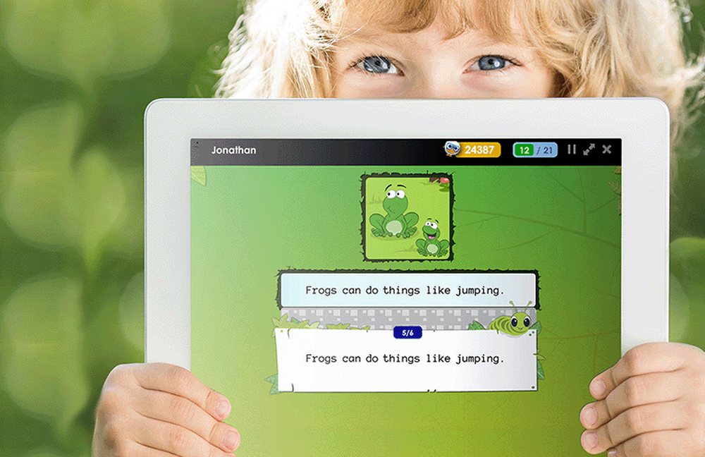 A child playing a Reading Kingdom learning game on a tablet